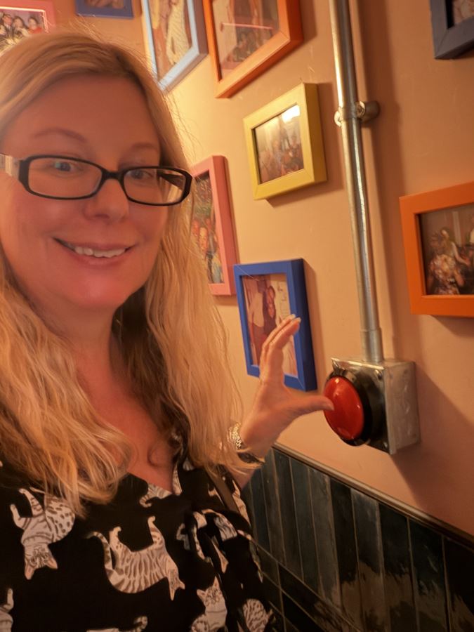 Helen from Differentville pushes the 'big red button' in one of the toilet stalls at Electric Shuffle in London's Kings Cross