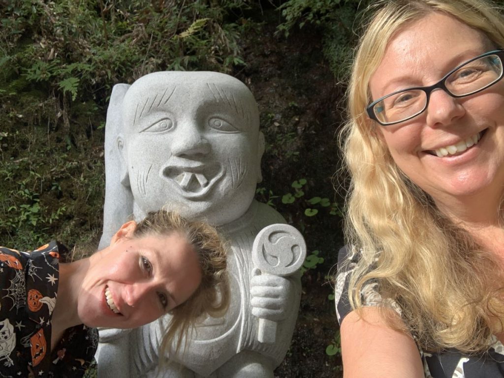 Helen from Differentville poses with one of the yokai statues in Oboke Japan