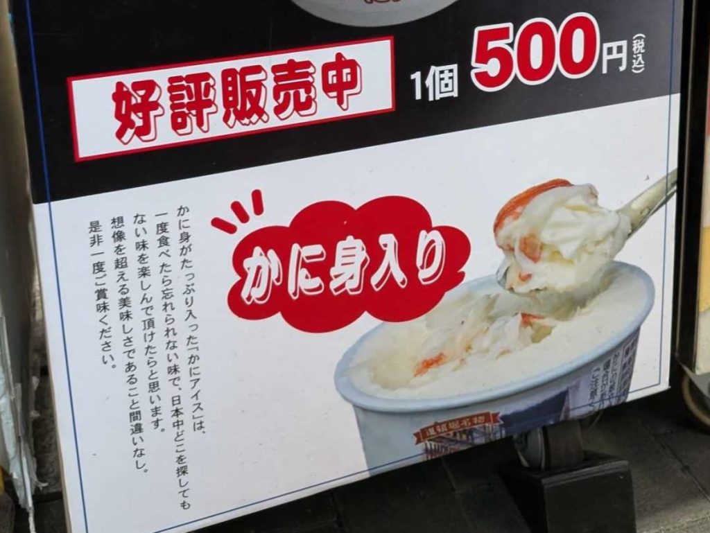Sales sign showing a spoonful of crab ice cream in Osaka