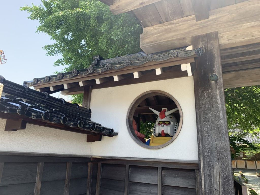 Close up of the Gundam looking out of the round window at Gyokuryuji in Kanazawa
