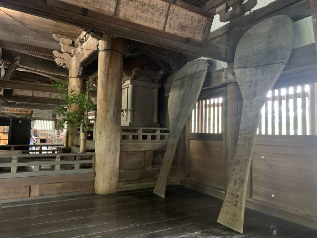 Large rice scoops - at least 6 feet tall - are propped up against the wall in Senjojaku hall in Miyajima