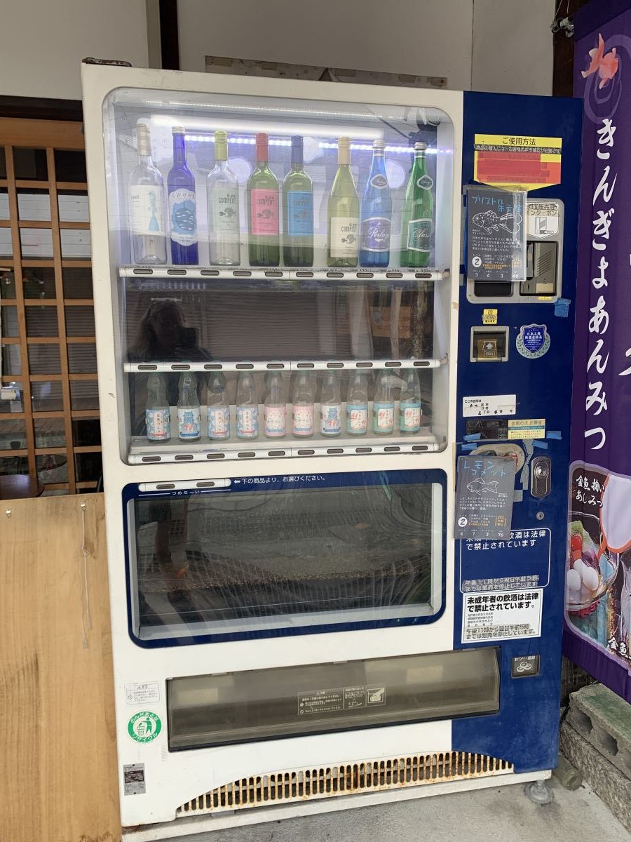 Vending machine of bottles of alcohol - a fish tank is in the middle of the machine