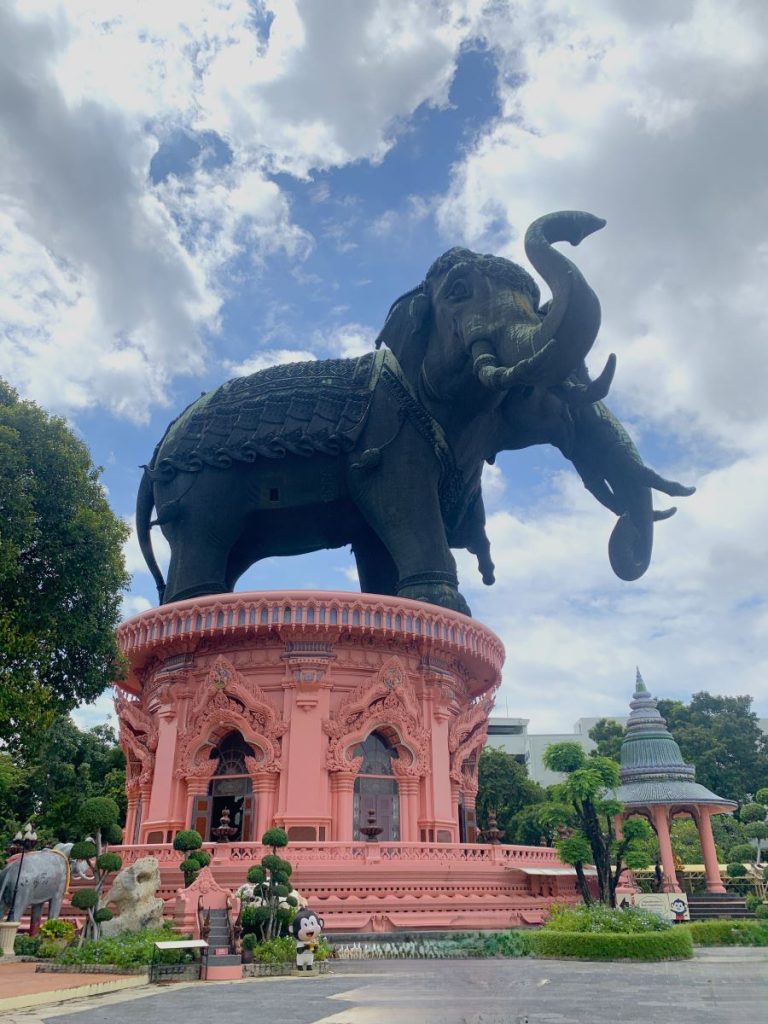Giant copper elephant with two heads stands on top of a salmon pink building at the Erawan Museum in Bangkok