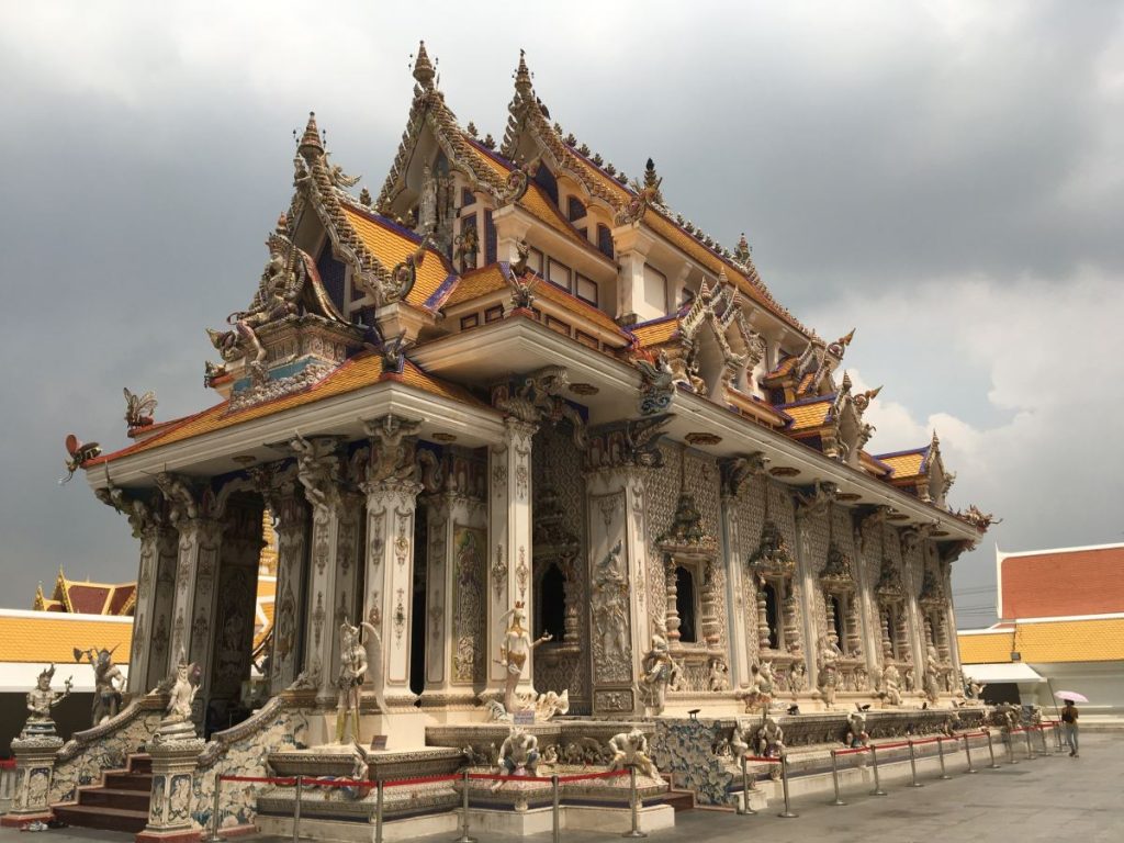 Exterior of Wat Pariwat in Bangkok showing the intricate carvings from a distance