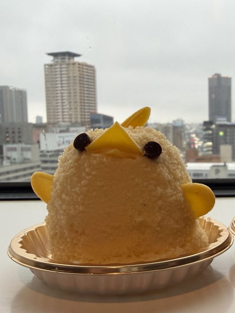 Yellow Piyorin chick cake sits in it's little tray on a windowsill
